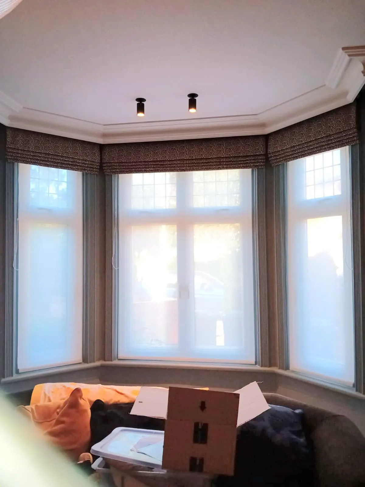 Roman blinds in a bay window with voiles